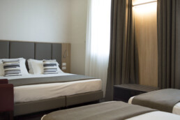Foto de una cama doble y dos camas individuales en una habitación Cuádruple